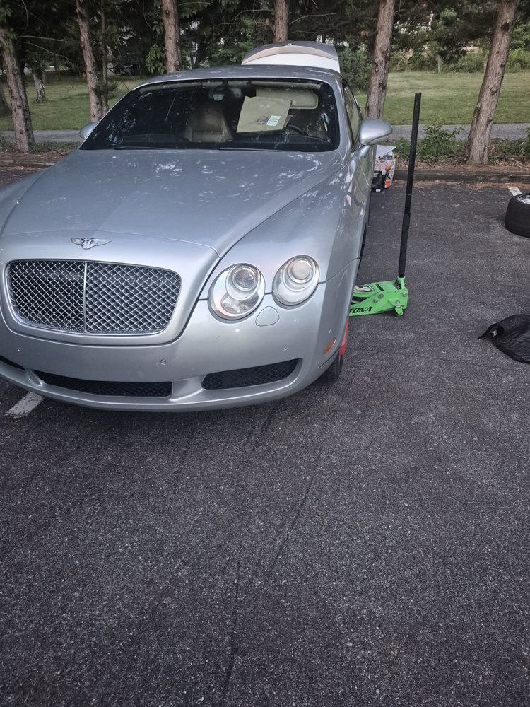 Luxury coupe raised on a jack during a mobile tire service in Maryland