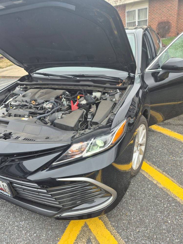 Battery jump start in progress on a Toyota Camry